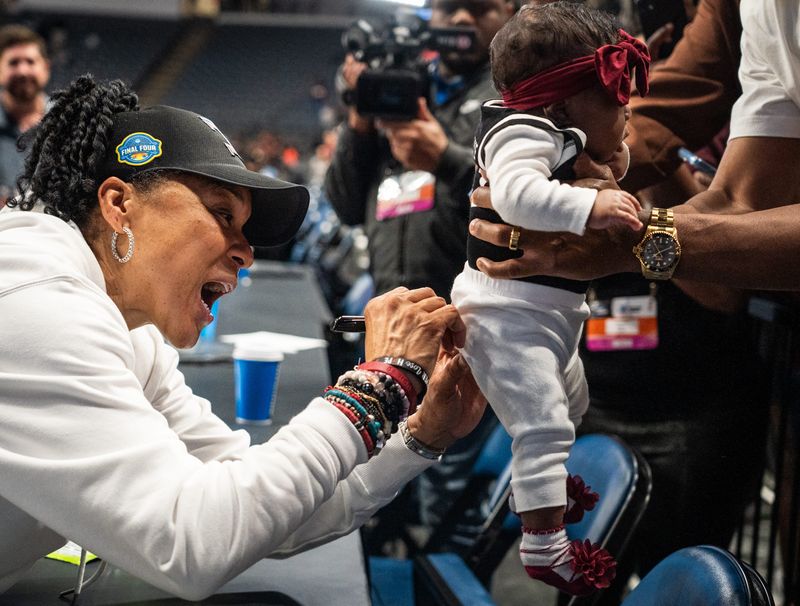 South Carolina Gamecocks head coach Dawn Staley signs a baby as the Gamecocks celebrate their NCAA Regional Final game win over Duke at Legacy Arena in Birmingham Alabama, March 30, 2025.