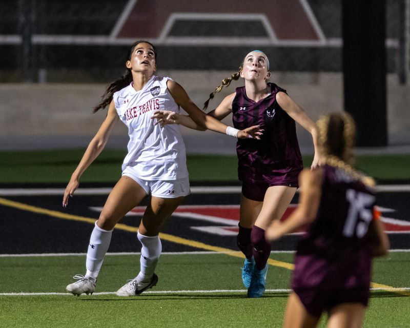 Lake Travis' Amelia Clark, left, and Round Rock's Carlee Deegan wait for the ball to drop during Tuesday night's Class 6A Division I regional final. The Cavs won 4-2 in a showdown of two of the state's top five-ranked teams.