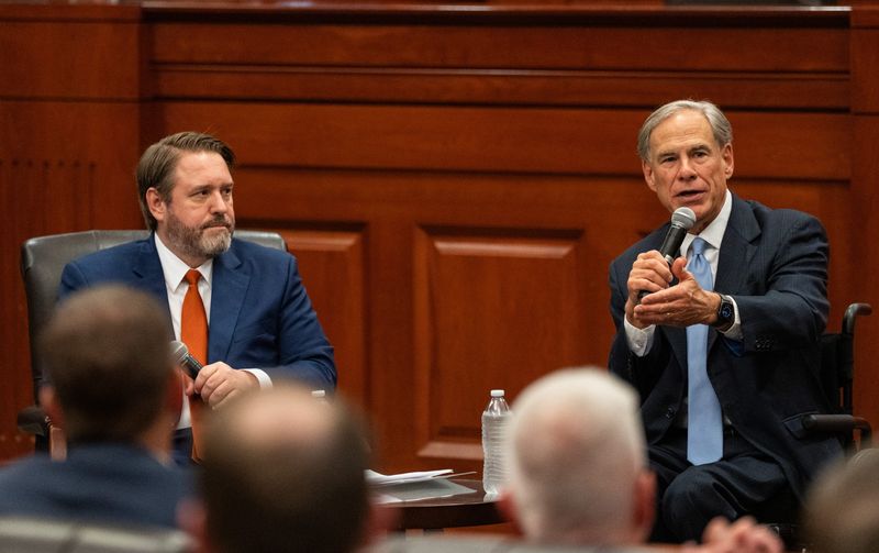 Gov. Greg Abbott talks with interim University of Texas President Jim Davis during a session Thursday at the University of Texas Law School.