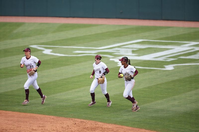Texas A&M center fielder Allie Enright (left), right fielder Frankie Vrazel (middle) and second baseman KK Dement (right) jog towards the dugout after an inning is over.