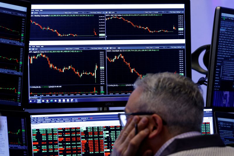FILE PHOTO: Traders work on the floor of the NYSE in New York