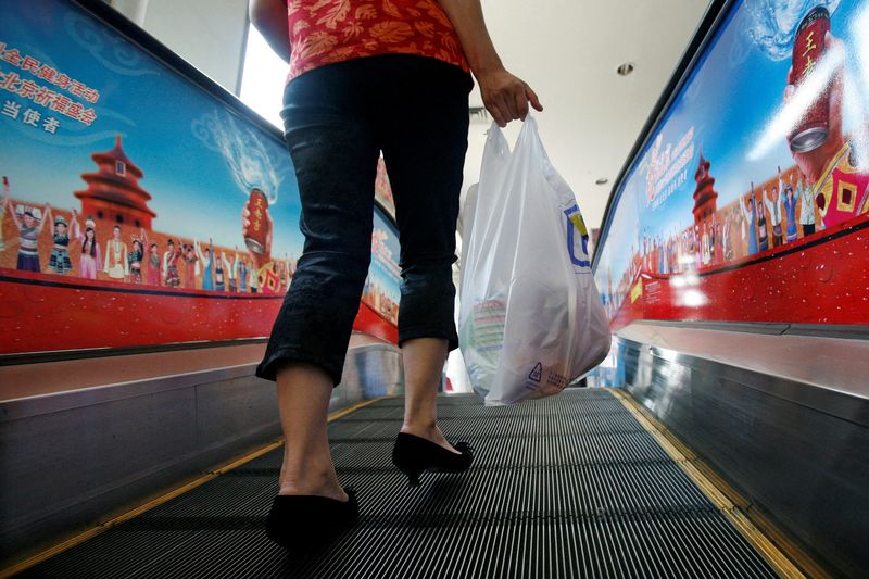 FILE PHOTO: A shopper carries groceries she bought in a plastic bag in Beijing