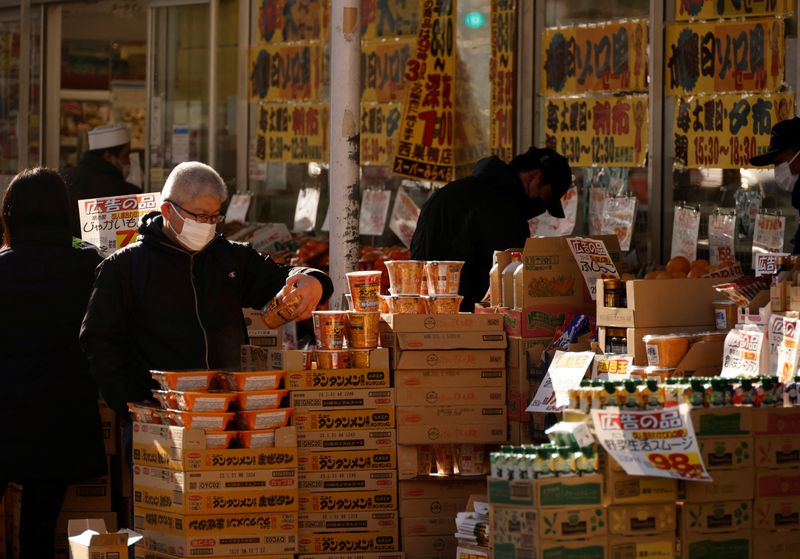 FILE PHOTO: Shoppers check foods at a supermarket in Tokyo, Japan January 10, 2023. REUTERS/Issei Kato/File Photo
