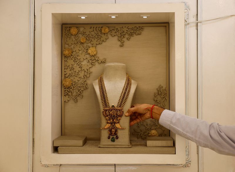 FILE PHOTO: A salesman shows a gold necklace on display inside a jewellery showroom in Kolkata, India, October 18, 2024. REUTERS/Sahiba Chawdhary/File Photo