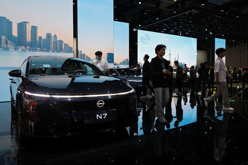 FILE PHOTO: People look at a Nissan N7 electric sedan at the Japanese carmaker's booth during a media day for the Auto Shanghai show in Shanghai, China April 23, 2025. REUTERS/Go Nakamura/File photo