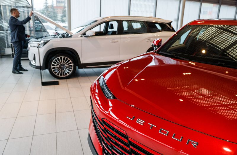 FILE PHOTO: A sales manager closes the hood of a crossover produced by Chinese automaker Jetour at the Keyauto dealership in Lyubertsy, in the Moscow Region, Russia July 12, 2023. REUTERS/Maxim Shemetov/File photo