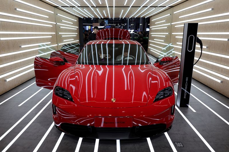 FILE PHOTO: People look at the Porsche Taycan GTS electric vehicle (EV) during a media day for the Auto Shanghai show in Shanghai, China April 23, 2025. REUTERS/Go Nakamura/File Photo