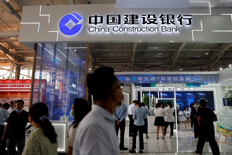 FILE PHOTO: People walk past the China Construction Bank booth at the 2021 China International Fair for Trade in Services (CIFTIS) in Beijing, China September 3, 2021. REUTERS/Florence Lo/File Photo