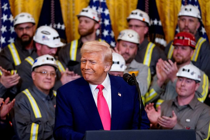 FILE PHOTO: U.S. President Donald Trump reacts next to coal industry workers, on the day he signs energy-related executive orders at the White House in Washington, D.C., U.S., April 8, 2025. REUTERS/Nathan Howard/File Photo