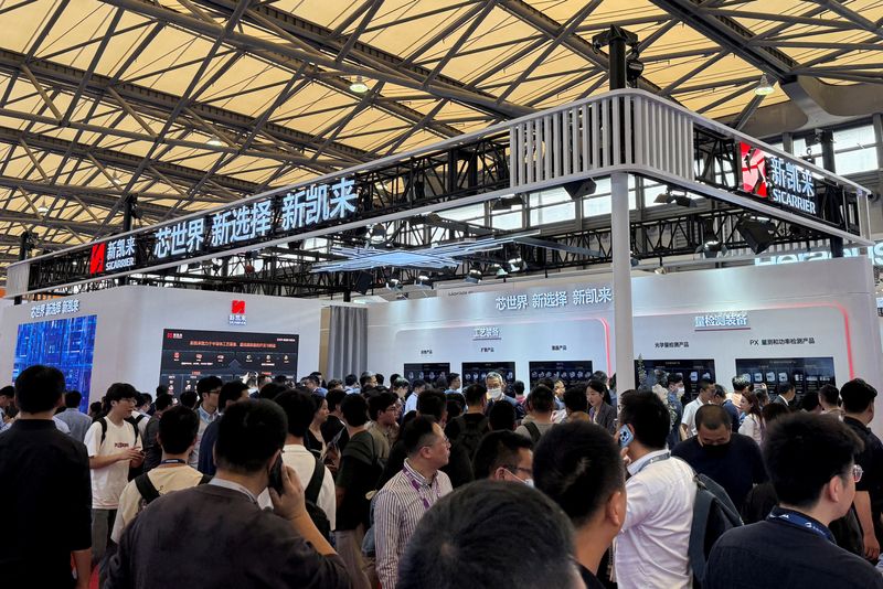 FILE PHOTO: Visitors walk past the SiCarrier booth during SEMICON China, a trade fair for the semiconductor industry, in Shanghai, China March 26, 2025. REUTERS/Che Pan/File Photo