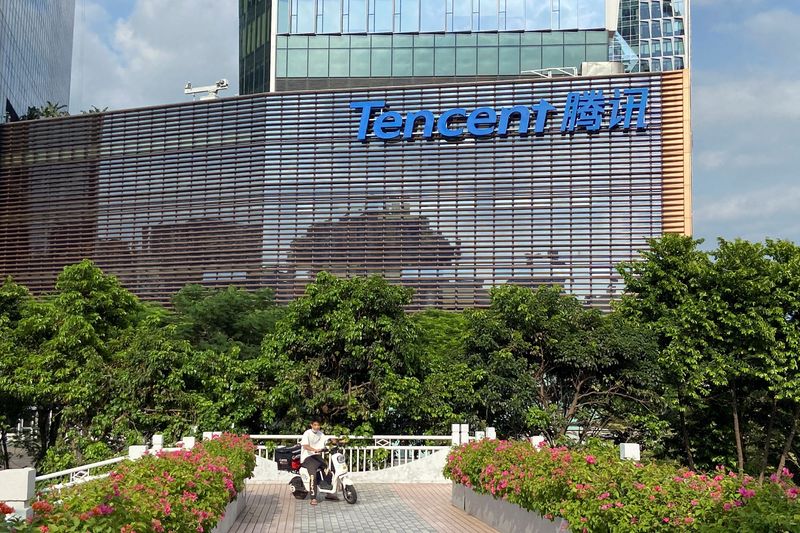 A man rides an electric bike past the Tencent headquarters in Nanshan district of Shenzhen, Guangdong province, China September 2, 2022. REUTERS/David Kirton/File Photo