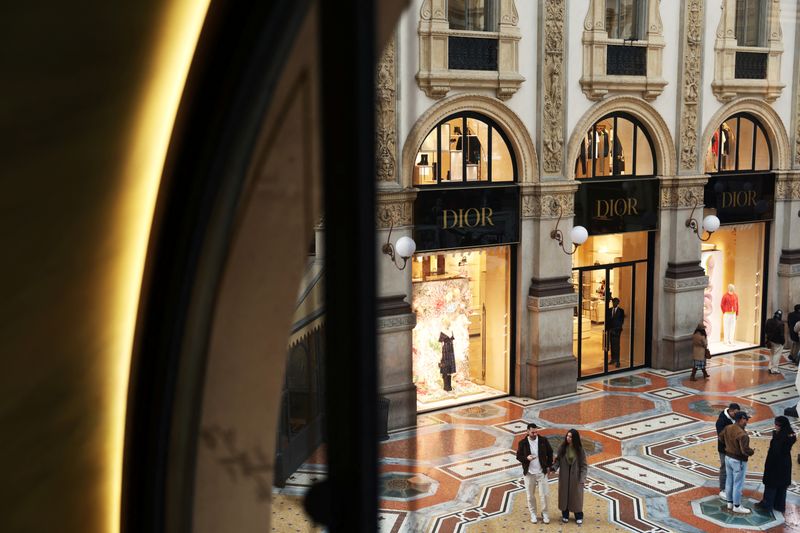 FILE PHOTO: People walk outside a Dior store in Galleria Vittorio Emanuele II in Milan