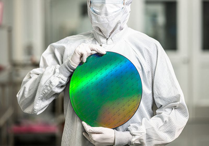 FILE PHOTO: An employee of startup PsiQuantum holds a silicon disc containing the company's quantum computing chips at a facility in San Jose, California, in an undated handout photo provided on February 25, 2025. Courtesy PsiQuantum/Handout via REUTERS/File Photo