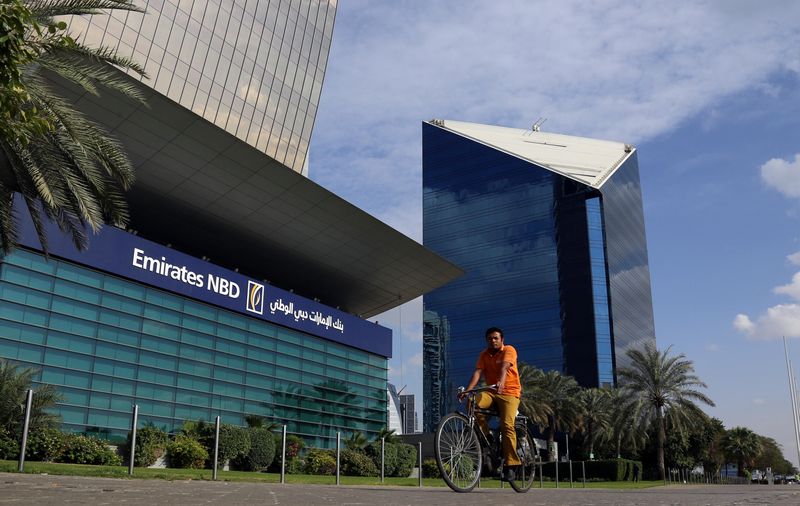 FILE PHOTO: A man rides a bicycle past Emirates NBD head office in Dubai, UAE January 30, 2018. REUTERS/Satish Kumar/File Photo