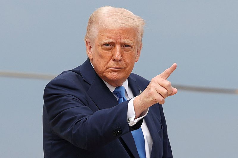 FILE PHOTO: U.S. President Donald Trump gestures, before boarding Air Force One as he departs for Florida, at Joint Base Andrews, Maryland, U.S., March 28, 2025. REUTERS/Kevin Lamarque/File Photo