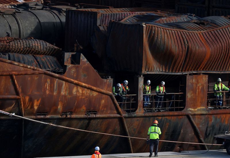 FILE PHOTO: Salvage workers examine the container ship Solong, damaged as a result of colliding with the anchored Stena Immaculate oil tanker ship after it was towed into the port of Aberdeen, Scotland, Britain, March 28, 2025. REUTERS/Phil Noble/File Photo