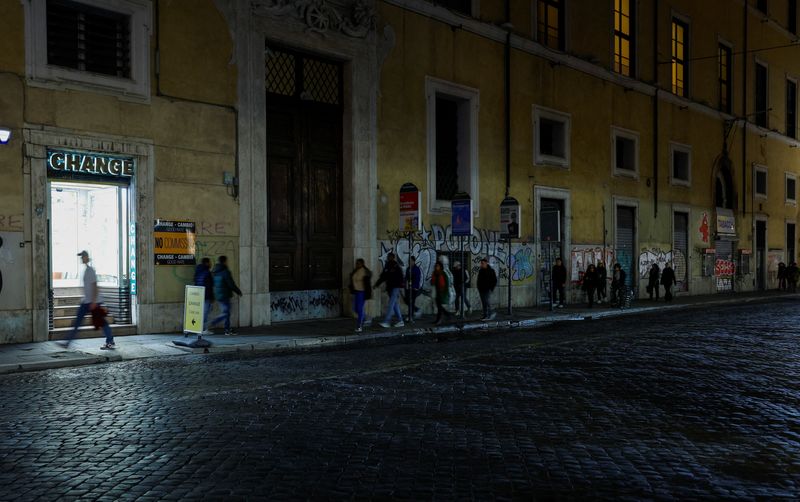 FILE PHOTO: People walk next to closed shops in downtown Rome, Italy, December 13, 2023. REUTERS/Remo Casilli/File Photo