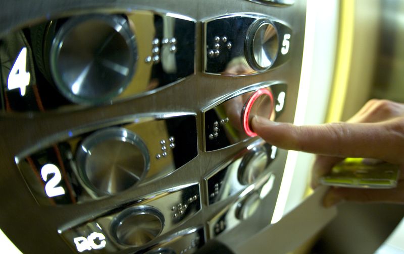 FILE PHOTO: A woman uses an elevator in a Paris' office October 22, 2008. Elevator make Otis will replace hundreds of lift buttons in France after authorities found radioactive materials imported from India at a supplier factory in eastern France.  REUTERS/Mal Langsdon/File Photo