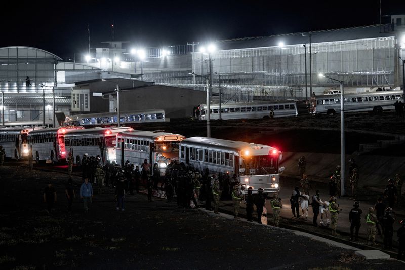 FILE PHOTO: Salvadoran police officers escort alleged members of the Venezuelan gang Tren de Aragua recently deported by the U.S. government to be imprisoned in the Terrorism Confinement Center (CECOT) prison, as part of an agreement with the Salvadoran government, in Tecoluca, El Salvador, in this handout image obtained March 16, 2025. Secretaria de Prensa de la Presidencia/Handout via REUTERS/File Photo