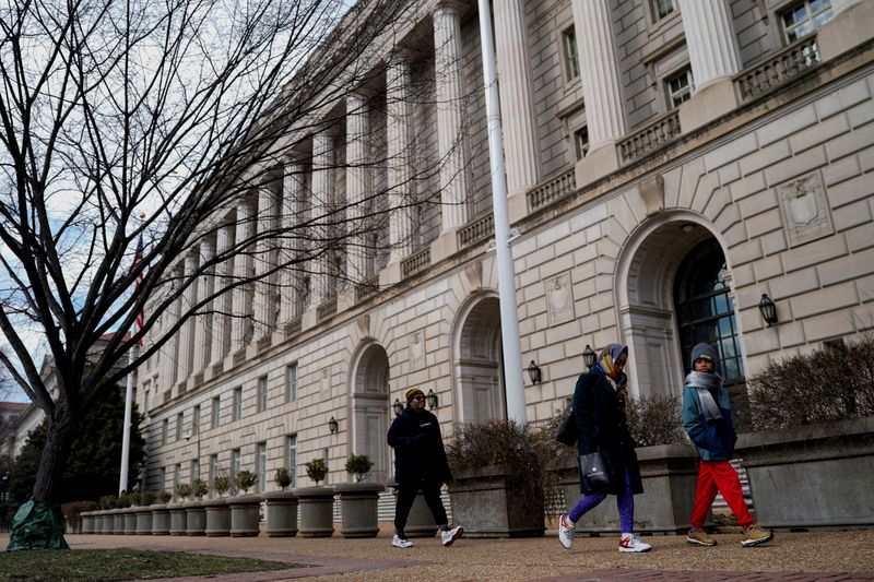 FILE PHOTO: People walk by the U.S. Internal Revenue Service (IRS) building in Washington, D.C., February 20, 2025. REUTERS/Kent Nishimura/File Photo