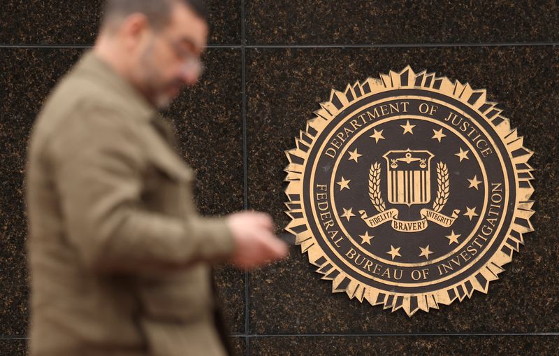 A person passes by the FBI seal on the wall of the FBI headquarters, days after the Trump administration launched a sweeping round of cuts at the Justice Department, in Washington, U.S., February 3, 2025. REUTERS/Kevin Lamarque