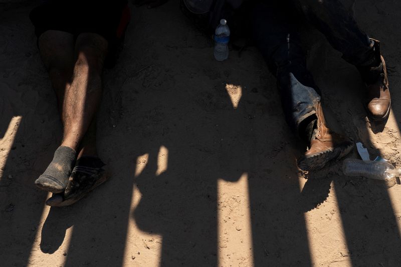 Asylum seeking migrants, mostly from Venezuela and Cuba, wait to be transported by U.S. Customs and Border Protection agents after crossing the Rio Grande river into the U.S. from Mexico at Eagle Pass, Texas, U.S., July 14, 2022.  REUTERS/Go Nakamura/File Photo
