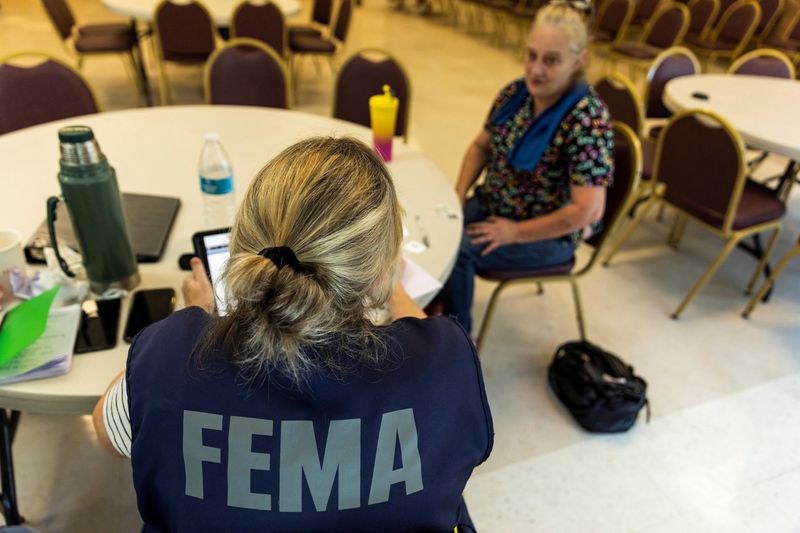 A FEMA worker attends a claim by a local resident after being affected by floods following the passing of Hurricane Helene, in Marion, North Carolina, U.S., October 5, 2024. REUTERS/Eduardo Munoz/File Photo