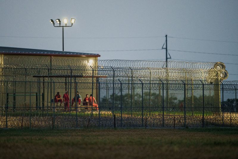 FILE PHOTO: Detainees sit outside at dusk at the Bluebonnet Detention Facility, the facility where Venezuelans at the center of a U.S. Supreme Court ruling are held, in Anson, Texas, U.S., April 27, 2025. REUTERS/Paul Ratje/File Photo