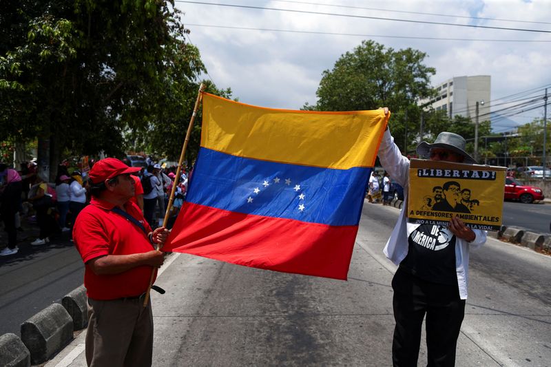 People hold a Venezuelan flag during a protest in support of Venezuelan citizens who were recently deported from the U.S. to El Salvador, in San Salvador, El Salvador March 24, 2025. REUTERS/Jose Cabezas