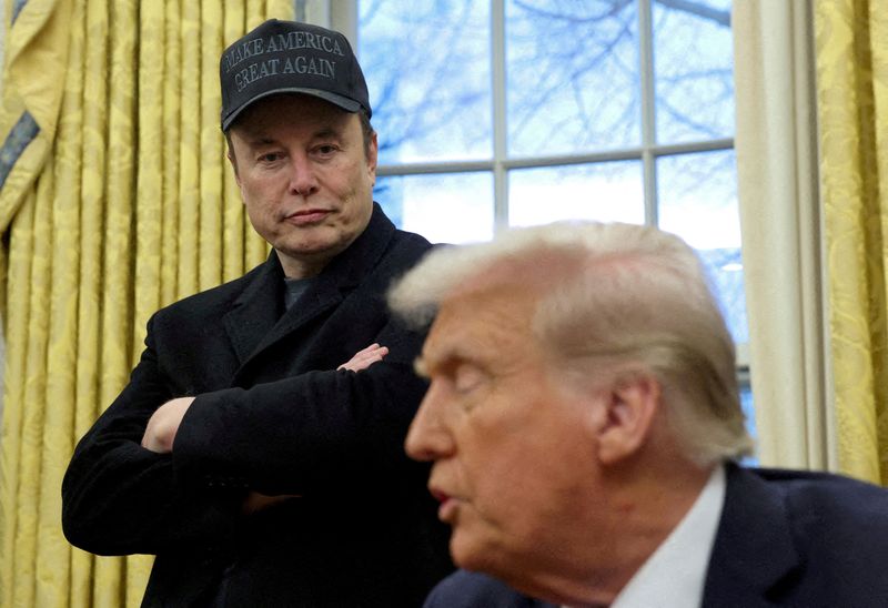 FILE PHOTO: Elon Musk listens to U.S. President Donald Trump speak in the Oval Office of the White House in Washington, D.C., U.S., February 11, 2025.   REUTERS/Kevin Lamarque//File Photo