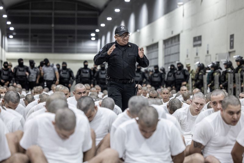 Alleged members of the Venezuelan gang Tren de Aragua recently deported by the U.S. government to be imprisoned in the Terrorism Confinement Center (CECOT) prison sit on the floor, as part of an agreement with the Salvadoran government, in Tecoluca, El Salvador, in this handout image obtained March 16, 2025. Secretaria de Prensa de la Presidencia/Handout via REUTERS