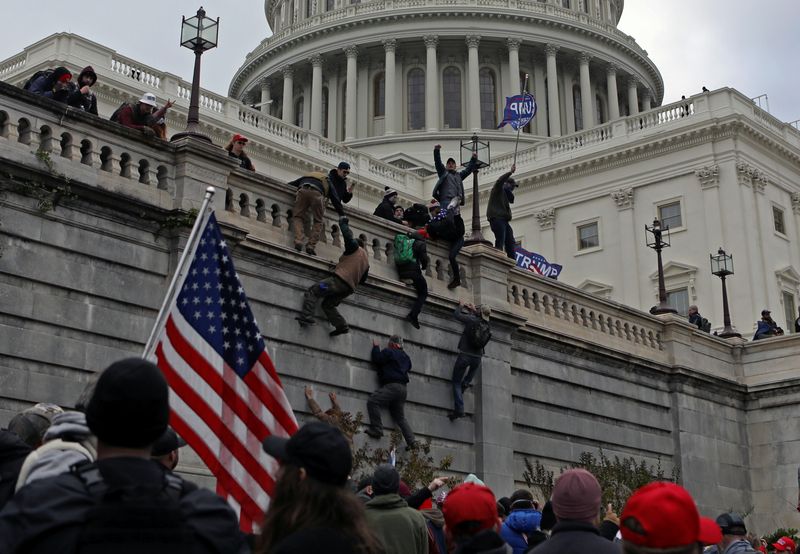 FILE PHOTO: Supporters of U.S. President Donald Trump climb a wall during a protest against the certification of the 2020 presidential election results by the Congress, at the Capitol in Washington, U.S., January 6, 2021. Picture taken January 6, 2021. REUTERS/Jim Urquhart/File Photo