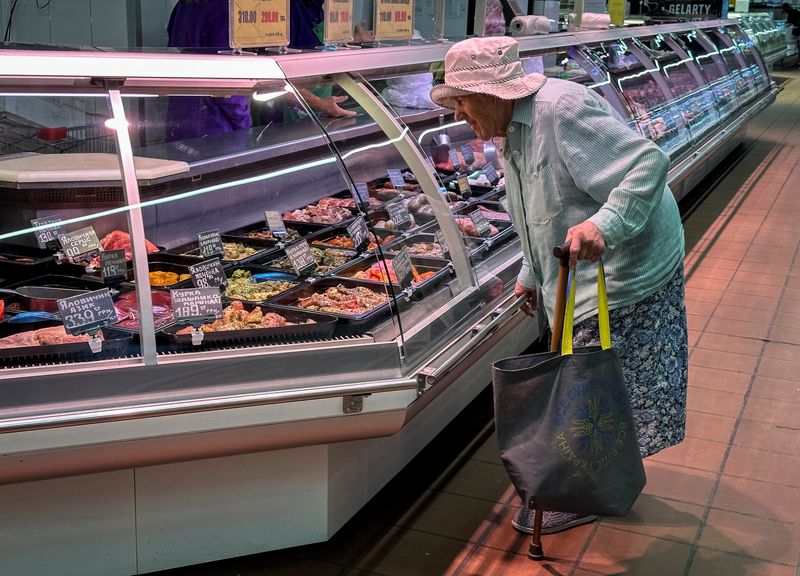 FILE PHOTO: An elderly Ukrainian woman looks at different meat products in a supermarket, amid Russia's attack on Ukraine, in Kyiv, Ukraine July 21, 2023. REUTERS/Gleb Garanich/File Photo