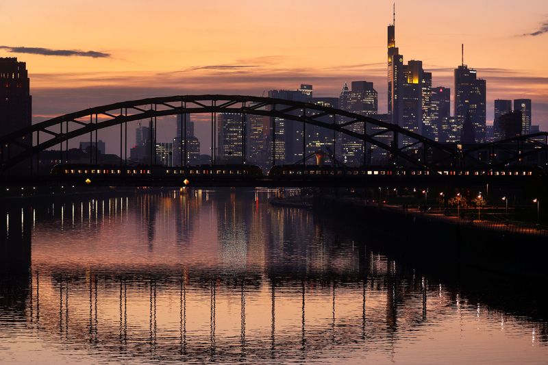 FILE PHOTO: A commuter train passes by the skyline with its financial district ahead of the European Central Bank?s (ECB)  governing council meeting later this week in Frankfurt, Germany, October 25, 2021.  REUTERS/Kai Pfaffenbach/File Photo