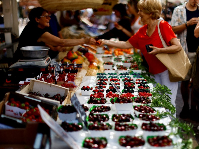 FILE PHOTO: Shoppers buy fruits at a local market in Nice, France, June 8, 2023. REUTERS/Eric Gaillard//File Photo