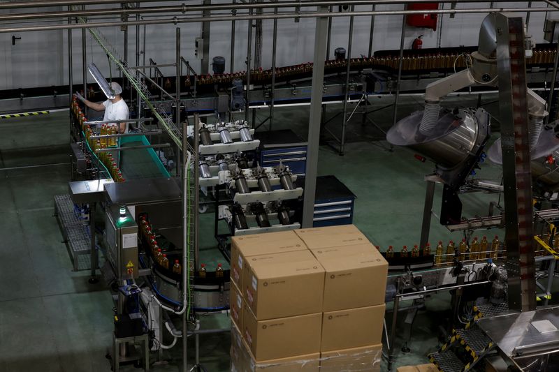 FILE PHOTO: A worker checks bottles of olive oil on the filling and packaging conveyor belt at the Spanish olive oil producer Dcoop's factory in Antequera, Spain, April 9, 2025. REUTERS/Jon Nazca/File Photo