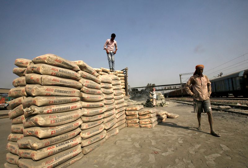 FILE PHOTO: Labourers stand after unloading cement bags from a freight train at Ghaziabad railway station on the outskirts of New Delhi, India, April 20, 2017. Picture taken April 20, 2017. REUTERS/Adnan Abidi/File Photo