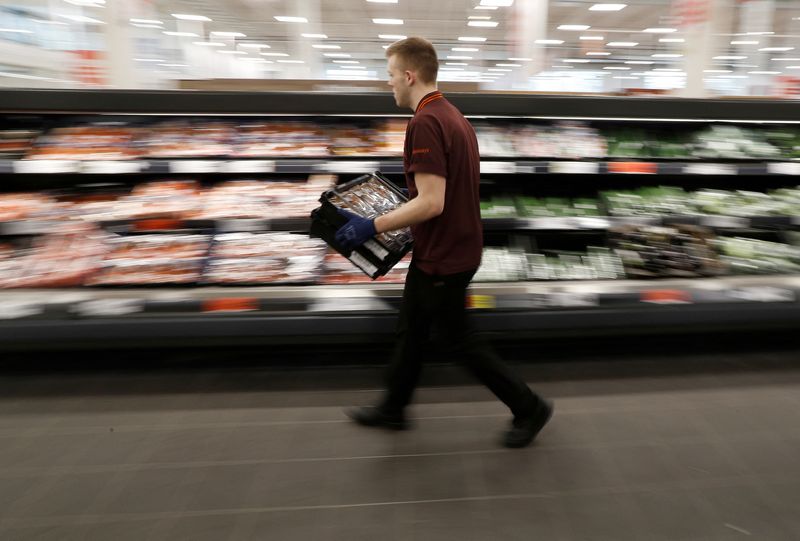 FILE PHOTO: A Sainsbury’s worker stacks a vegetable shelf in a store in Redhill