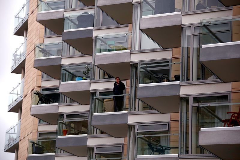 A man smokes a cigarette on the balcony of a recently constructed residential apartment building in central Wellington, New Zealand