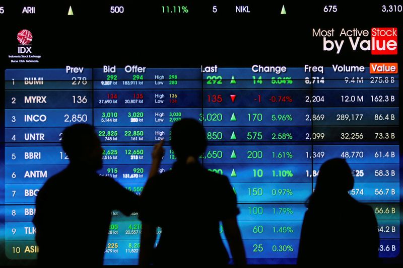 FILE PHOTO: Visitors stand next to an electronic stock board at the Indonesia Stock Exchange in Jakarta, Indonesia November 8, 2016.REUTERS/Iqro Rinaldi/File Photo
