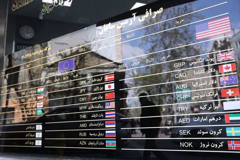 The American flag is seen on a sign board at a currency exchange as the value of the Iranian Rial drops, in Tehran, Iran, March 26, 2025. Majid Asgaripour/WANA (West Asia News Agency) via REUTERS