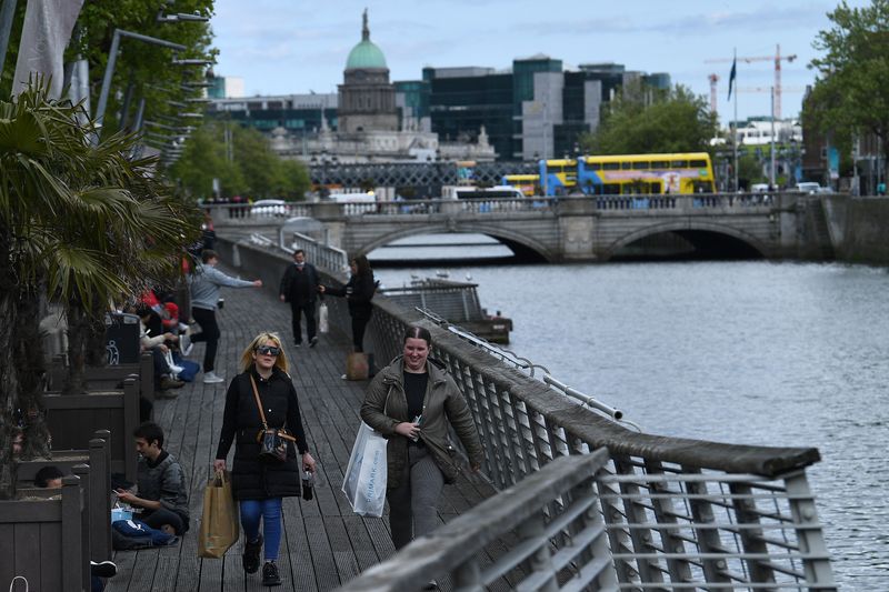 FILE PHOTO: Shoppers walk along the boardwalk on the river Liffey in Dublin, Ireland, May 17, 2021. REUTERS/Clodagh Kilcoyne/File Photo
