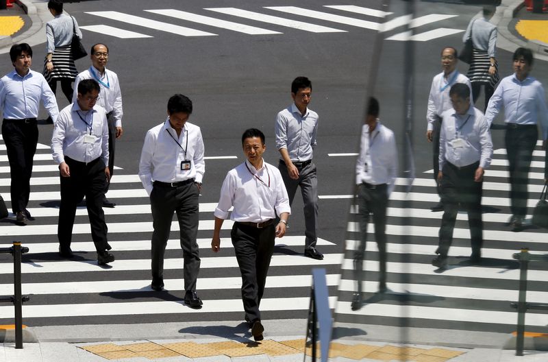FILE PHOTO: Office workers are reflected in a glass railing as they cross a street during lunch hour in Tokyo June 1, 2015. REUTERS/Thomas Peter/File Photo