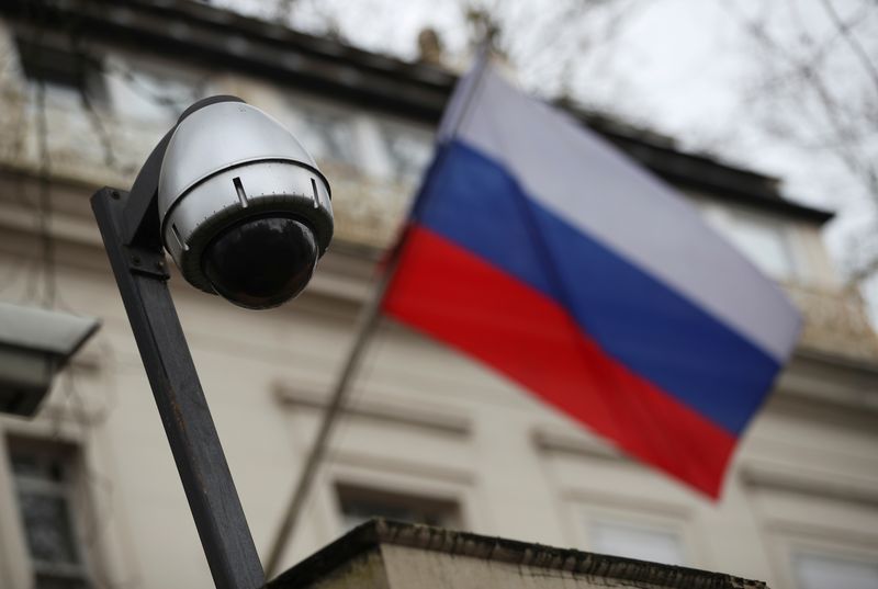 A security camera is seen, and a flag flies outside the consular section of Russia’s embassy in London