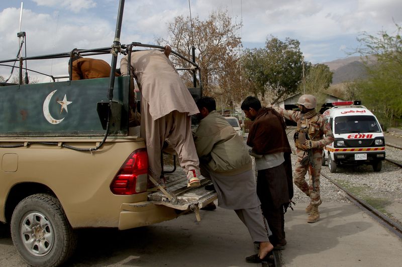 Plain clothes security force perosnnel, who were rescued from a train after it was attacked by separatist militants, arrive at a railway station in Mach
