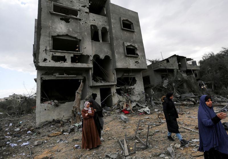 FILE PHOTO: Palestinians inspect the site of an Israeli strike on a house, in Khan Younis in the southern Gaza Strip March 20, 2025. REUTERS/Hatem Khaled/File Photo