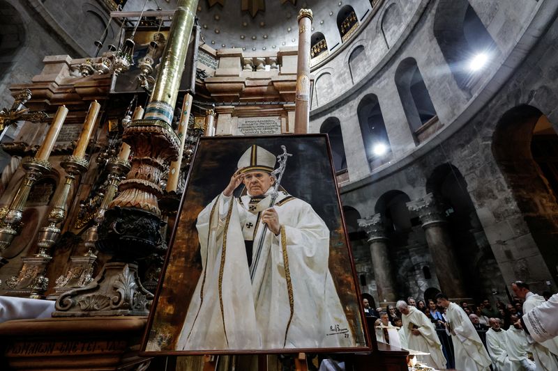 A framed photo of Pope Francis is on display at the Church of the Holy Sepulchre in Jerusalem's Old City during Mass for the late pontiff April 23, 2025. REUTERS/Ammar Awad