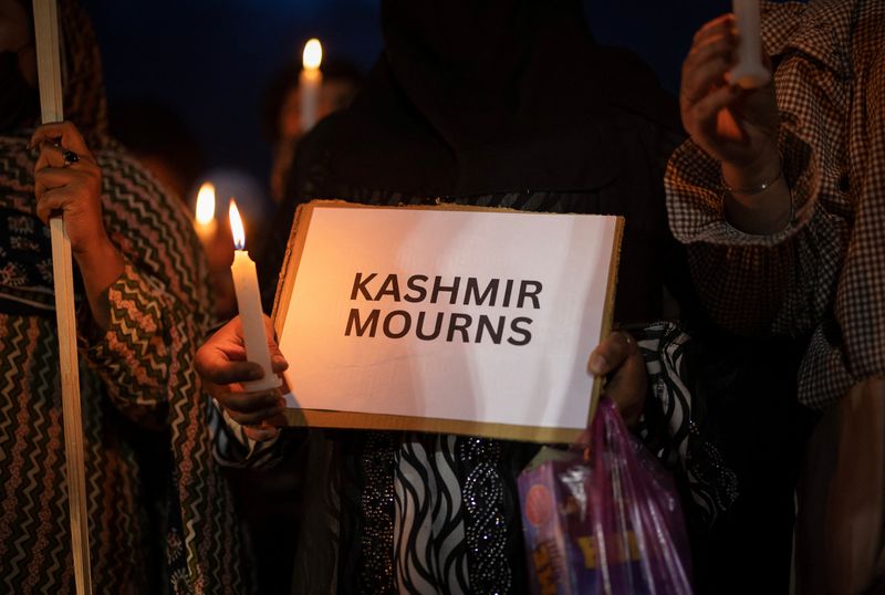 A demonstrator holds a placard with a message and a candle during a candlelight vigil to condemn the attack on tourists, following a suspected militant attack near south Kashmir’s scenic Pahalgam, in Srinagar April 23, 2025. REUTERS/Adnan Abidi