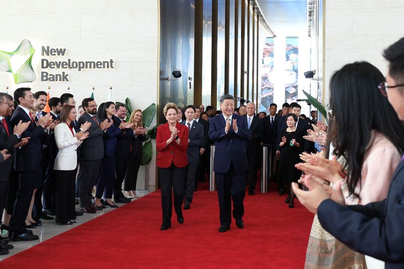 Chinese President Xi Jinping applauds next to Dilma Rousseff, President of New Development Bank, as he visits the multilateral bank of BRICS member nations, in Shanghai, China April 29, 2025. cnsphoto via REUTERS