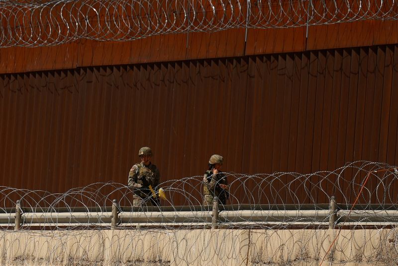 Texas National Guard soldiers walk near the U.S.-Mexico border wall, as seen from Ciudad Juarez, Mexico, March 11, 2025. REUTERS/Jose Luis Gonzalez/File Photo